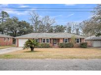 Charming single-story brick home with well-maintained landscaping and a quaint front yard and single car garage at 6017 Ridgecrest Ave, Hanahan, SC 29410