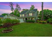 Charming two-story home featuring a well-manicured lawn, landscaping, and inviting curb appeal at 616 W 2Nd N St, Summerville, SC 29483