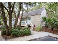 Charming home with a quaint front porch, mature trees, and landscaped yard, creating a serene and inviting curb appeal at 625 Double Eagle Trce, Seabrook Island, SC 29455