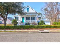 Charming two-story home featuring a welcoming front porch and a well-manicured lawn with lush green hedges at 6902 Tanner Hall Blvd, Hanahan, SC 29410