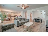 Open-concept living room showcasing modern furniture, wood floors and seamless flow to kitchen and dining areas at 9830 Black Tupelo Ln, Ladson, SC 29456