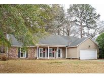 Charming single-story home with a welcoming front porch, beautiful landscaping, and an attached two-car garage at 112 Chownings Ln, Goose Creek, SC 29445