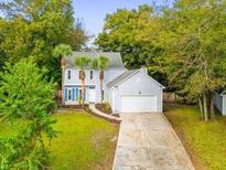 Charming two-story home featuring a well-manicured lawn, mature trees, and attached garage at 1294 Horseshoe Bnd, Mount Pleasant, SC 29464