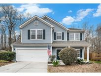 Charming two-story home featuring blue siding, black shutters, well-manicured landscaping, and a two-car garage at 223 Chipping Sparrow Drive Dr, Summerville, SC 29485