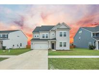 Charming two-story home with gray siding, well-manicured lawn, and attached two-car garage at 296 Firewheel Ct, Summerville, SC 29486