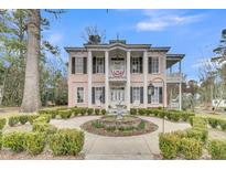 Charming two-story home with columns, fountain and landscaped front yard at 301 E Richardson Ave, Summerville, SC 29483