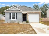 Charming single-story home featuring vinyl siding, brick accents, and an attached one car garage at 604 Red Mulberry Rd, Moncks Corner, SC 29461
