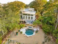 Stunning home with modern architectural details surrounded by lush landscaping and a beautiful pool and spa area at 608 W Beach Ct, Folly Beach, SC 29439