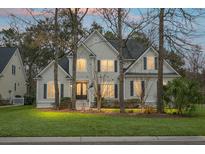 Charming two-story home with well-manicured lawn and mature trees creating a peaceful and inviting atmosphere at 6917 Tanner Hall Blvd, Hanahan, SC 29410
