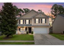 Charming two-story home featuring tan siding, black shutters, a well-manicured lawn, and an attached two-car garage at 123 Hammerbeck Rd, Summerville, SC 29483