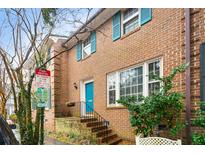 Charming brick townhome showcasing blue shutters and door, surrounded by lush greenery, with a classic architectural appeal at 133 Wentworth St, Charleston, SC 29401