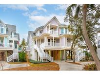 Three story elevated beach home with wrap-around porch and white railings at 1607 Folly Creek Way Way # C-5, Charleston, SC 29412