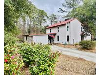 Charming two-story home with a red roof, mature trees and a beautiful garden at 204 Chamblee Rd, Walterboro, SC 29488