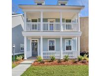 Charming two-story home with double covered porches, white columns, and manicured landscaping at 2205 Blue Bayou Blvd, Johns Island, SC 29455