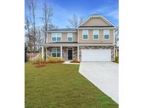 Two story home featuring stone accents, a two car garage, and a well maintained lawn at 2912 Siebold Dr, North Charleston, SC 29406