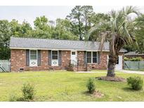 Charming brick home featuring a well-manicured lawn and mature trees at 2916 Marginal Rd, Charleston, SC 29414