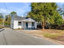 Charming renovated home featuring a blue front door, white siding, dark trim, and mature landscaping at 4625 Durant Ave, North Charleston, SC 29405