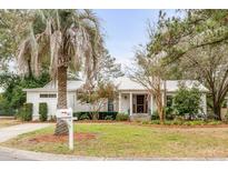 Charming single-story home with well-manicured lawn, mature trees, and inviting front porch at 521 London Bridge Rd, Mount Pleasant, SC 29464