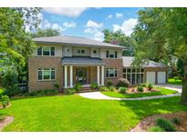 Beautiful brick home with a manicured lawn, mature trees, and a two car garage at 652 E Hobcaw Dr, Mount Pleasant, SC 29464
