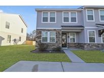 Charming townhome featuring stone accents, light gray siding, and a well-manicured front lawn at 7806 Park Gate Dr, North Charleston, SC 29418