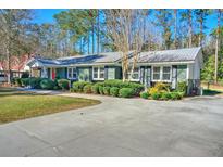 Charming ranch-style home featuring a well-maintained lawn, mature trees, and a concrete driveway at 114 Sharon Dr, Walterboro, SC 29488