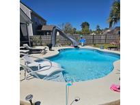 Inviting backyard pool with a slide, basketball hoop, and lounge chairs perfect for relaxation and summer fun at 1915 Sweetfern Rd, Hanahan, SC 29410