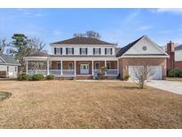 Inviting two-story home with a spacious front porch and attached two-car garage at 193 Shadowmoss Pkwy, Charleston, SC 29414