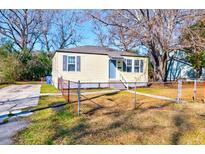 Charming single-story home with blue door, grey shutters, and chain link fence at 2694 Olympia Ave, North Charleston, SC 29405