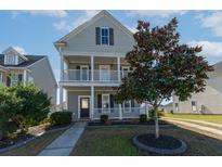 Charming two-story home featuring double porches, a manicured lawn, and mature landscaping at 309 Peters Creek Dr, Summerville, SC 29486