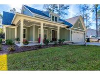 Charming home featuring a welcoming front porch and attached two-car garage at 418 Myers Mayo Rd, Ridgeville, SC 29472