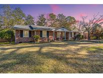 Charming brick home with a well-maintained lawn and inviting front porch at 6024 Meadowcliff Ave, Hanahan, SC 29410
