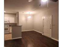 View of the living room with hardwood floors and an open kitchen featuring white cabinets at 1600 Long Grove Dr # 1214, Mount Pleasant, SC 29464
