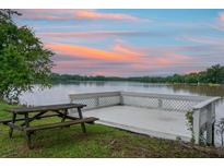 Picturesque lakeside property with picnic table and spacious dock overlooking tranquil water at sunset at 1721 Pimlico Blvd, Moncks Corner, SC 29461