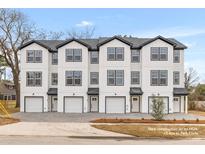New townhouse construction features white siding, black trim, garage, and charming front entrance at 2191 Helm Ave, North Charleston, SC 29405