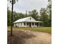 Charming single-story home features a metal roof, screened porch, and well-maintained lawn at 5585 Wire Road, Branchville, SC 29432