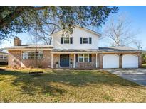 Charming brick home with swing in front yard and a two car garage on a sunny day at 5803 W Lakeside Dr, Hanahan, SC 29410