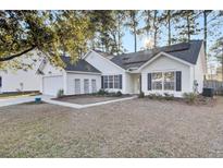 Charming single-story home with white siding, solar panels, and a well-maintained front yard at 7271 Sweetgrass Blvd, Hanahan, SC 29410