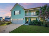 Charming two-story home featuring a light teal exterior, a welcoming porch, and a well-manicured lawn at 1089 Fort Johnson Rd, Charleston, SC 29412
