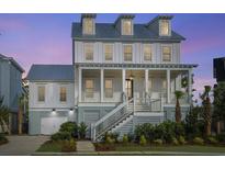 Beautiful two-story home featuring a welcoming front porch, landscaped yard, and a charming coastal design at 1468 Alligator Creek Ct, Awendaw, SC 29429
