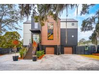 Stunning exterior elevation of a modern two-story home with a metal roof, wood accents, and a two-car garage at 231 Bayview Dr, Mount Pleasant, SC 29464