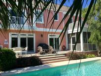 A beautiful outdoor pool area with a deck and seating, perfect for relaxation and entertaining guests at 24 Commons Ct, Isle of Palms, SC 29451