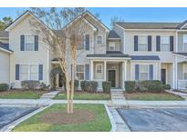 Inviting exterior view of townhomes with manicured lawns, blue shutters, and covered entryway at 249 Brookshire Rd, Goose Creek, SC 29445