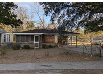 Exterior view of home with a screened-in porch, weathered details, and mature trees at 2549 Taylor St, North Charleston, SC 29406