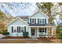 Charming two-story home featuring light blue siding, black shutters and a welcoming front porch with rocking chairs at 716 Muirhead Rd, Mount Pleasant, SC 29464