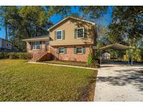 Charming two-story home with a brick facade, manicured lawn, and covered parking at 7639 Northhaven Dr, North Charleston, SC 29420