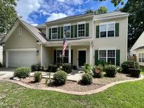 Charming two-story home with green shutters, an American flag, and well-maintained landscaping at 9656 Pebble Creek Blvd, Summerville, SC 29485