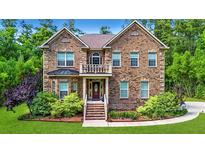 Charming brick two-story home featuring a manicured lawn and lush landscaping at 1208 Red Buckeye Ct, Moncks Corner, SC 29461