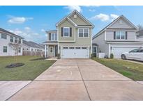 Two-story home with green siding, a two-car garage, and a long concrete driveway at 132 Mcclellan Way, Summerville, SC 29483