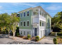 Charming two-story home with a double porch, green siding, and well-maintained landscaping at 17 Trumbo St, Charleston, SC 29401