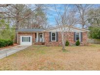 Charming brick home featuring a well-maintained front yard and classic architectural details at 214 Terry Ave, Summerville, SC 29485